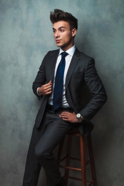 bir taburede oturan ve takımı'nın yaka tutarak işadamı