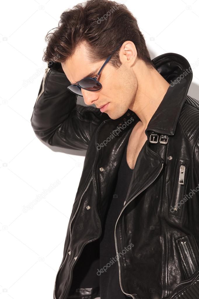 sad fashion man in leather jacket looking down