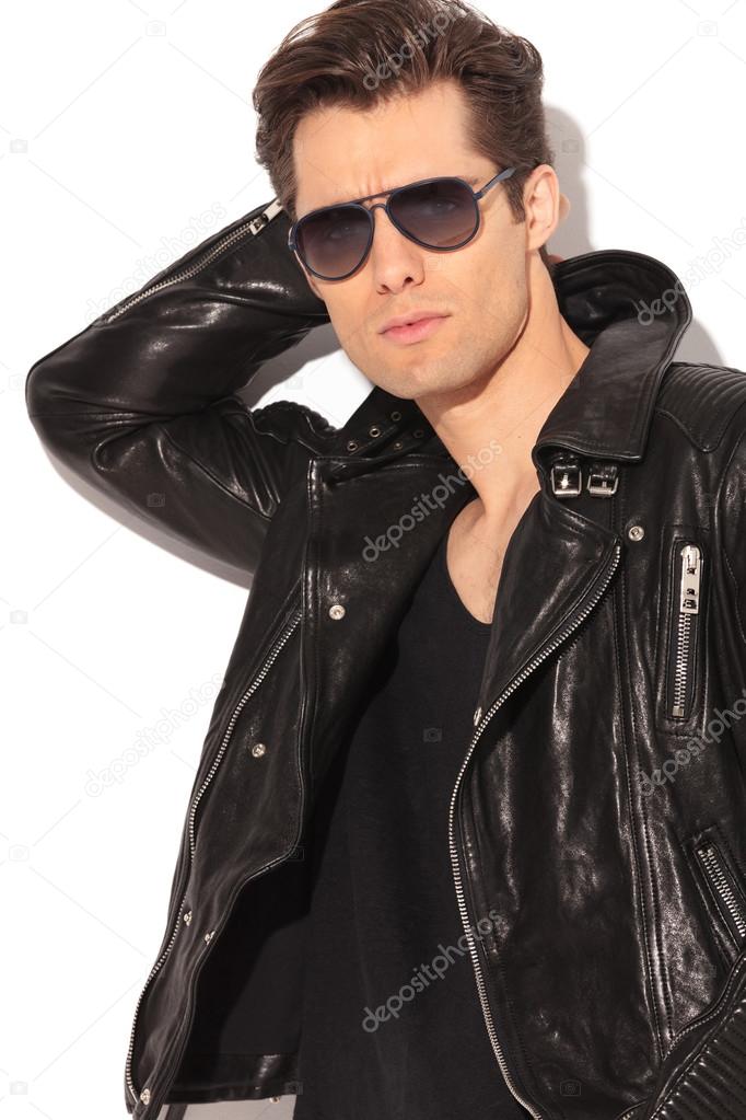  cool rocker in leather jacket holding hand behind head