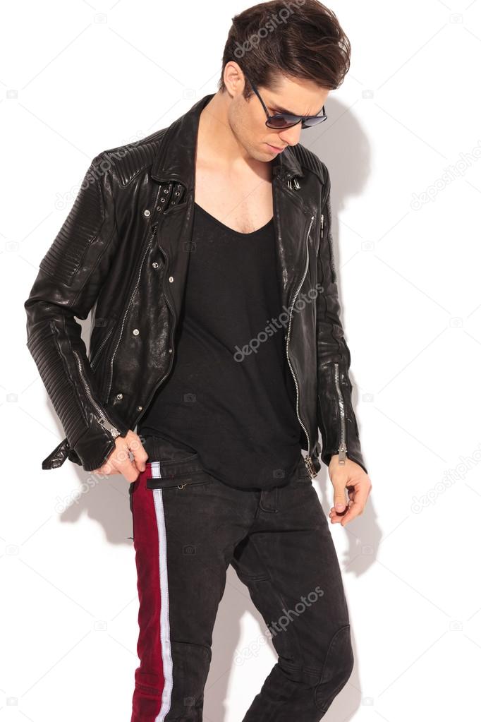 fashion man in leather jacket and sunglasses looking down
