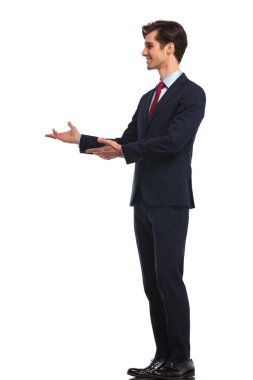 genç gülümseyen iş adamı sunan yan 