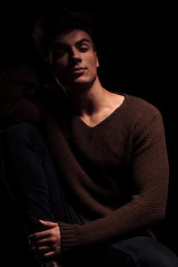 kamera için poz oturan genç çekici adam 