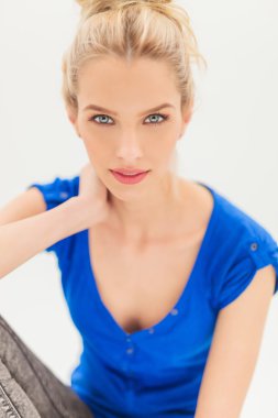 gülümser ve boyun arkasında tutan güzel sarışın kadın