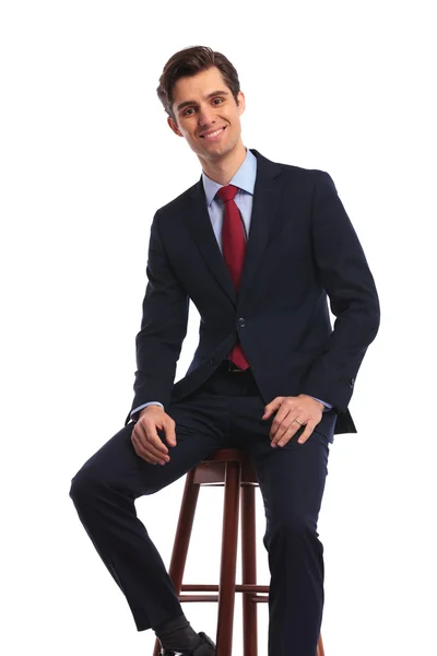 Sikeres fiatal üzletember ül egy széken — Stock Fotó