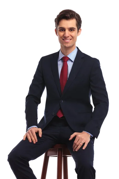 Siedzący szczęśliwy biznes człowiek trzyma ręce na kolana — Zdjęcie stockowe