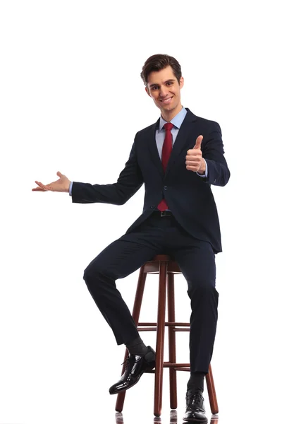 Sentado hombre de negocios hace que el ok pulgares hacia arriba signo mientras se presenta — Foto de Stock