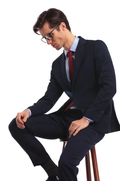 Vista lateral de un hombre de negocios sentado con gafas pensando — Foto de Stock