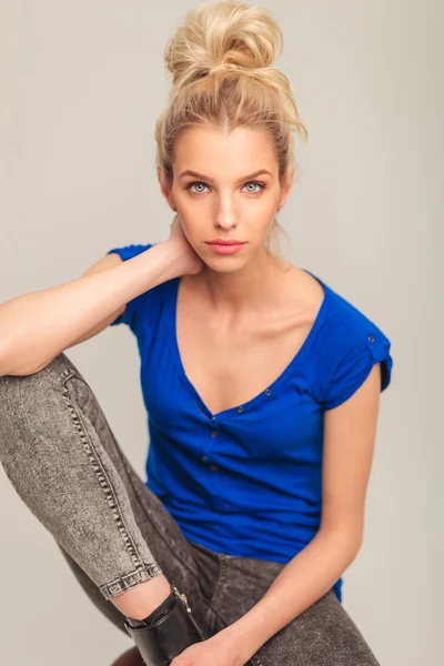 Portrait of a seated blonde woman in jeans — Stock Photo, Image