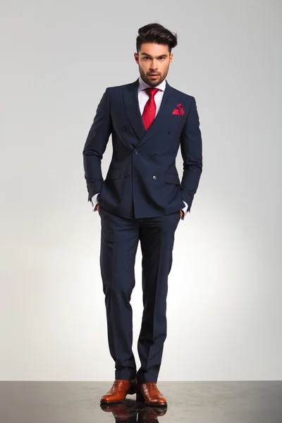 Бизнесмен в двубортном костюме, стоящий с поднятыми руками — стоковое фото