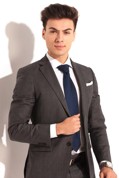 Serious young business man holding his collar — Stock Photo, Image