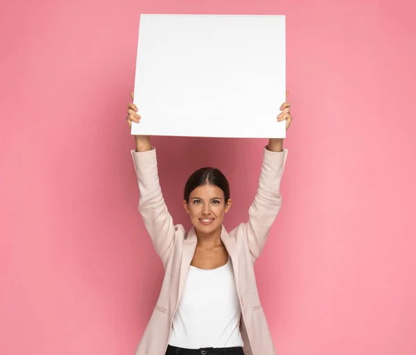 Beautiful Businesswoman Holding Blank Billboard Overhead Smiling Pink Background — Stock Photo, Image