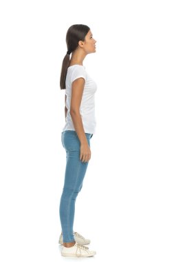 Beyaz stüdyo arka planında duran, ileriye bakan, odaklanmış sıradan bir kadının yan görüntüsü