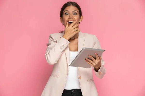 Linda Mujer Negocios Siente Emocionada Sosteniendo Tableta Tocando Cara Fondo —  Fotos de Stock