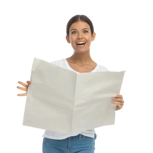 Podekscytowana Kobieta Czytająca Gazety Śmiejąca Się Stojąc Białym Tle Studia — Zdjęcie stockowe