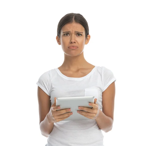 Αναστατωμένη Περιστασιακή Γυναίκα Κρατώντας Tablet Ενώ Στέκεται Λευκό Φόντο Στούντιο — Φωτογραφία Αρχείου