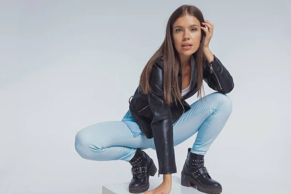 Modelo Moda Enfocada Ajustando Cabello Usando Chaqueta Cuero Mientras Agacha —  Fotos de Stock