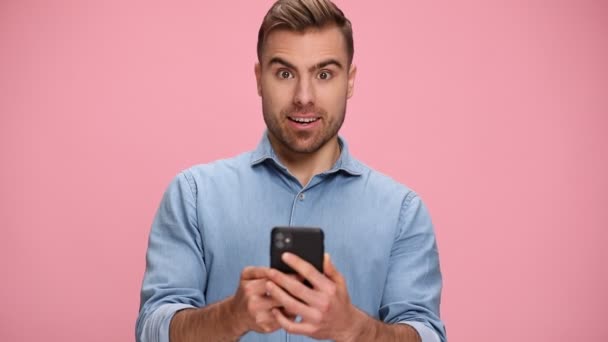 Surprised Young Casual Man Blue Shirt Holding Phone Reading Messages — Αρχείο Βίντεο