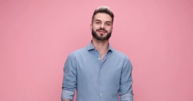 casual smiling man clapping his hands, pointing at the camera and feeling excited on pink background