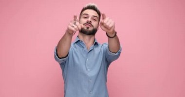 attractive casual man gesturing you, come over here against pink background