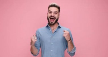 excited casual man celebrating succes, mocking someone and framing against pink background