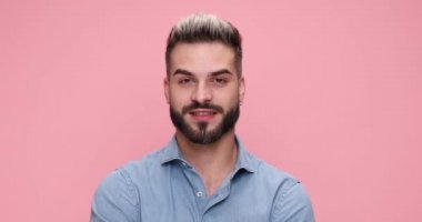 Çekici, sıradan bir adam gülüyor, üzgün hissediyor ve sonunda pembe arka planda sert bir tutum sergiliyor.