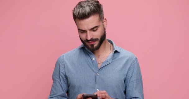 Casual Man Sms Zijn Telefoon Lachen Roze Achtergrond — Stockvideo