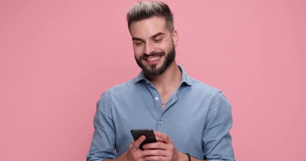 Ležérní Člověk Psaní Zprávy Svém Telefonu Ukazuje Kameru Růžovém Pozadí — Stock video