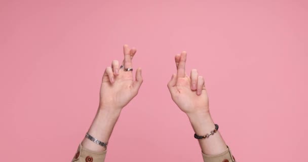 两只手握着手指 在粉色背景下祈求好运 — 图库视频影像