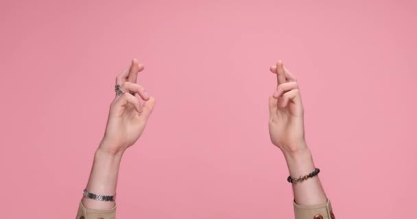 Two Hands Holding Fingers Crossed Showing Palms Dancing Pink Background — Vídeo de Stock