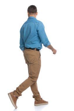 Sıradan bir adamın beyaz arka planda yürürken diğer tarafa bakması.