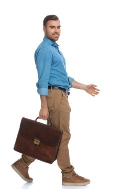 Çekici, sıradan bir adam beyaz arka plana karşı elinde bir çantayla yan yana yürüyor.