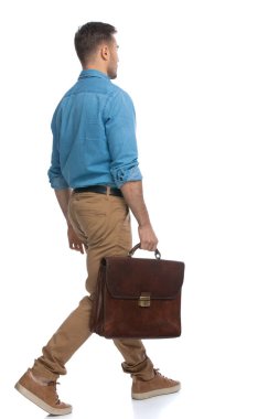 Genç, sıradan bir adamın beyaz arka planda yürüdüğü ve elinde bir çantayla yürüdüğü arka plan.