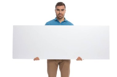Elinde geniş bir ilan panosu olan ve beyaz arka plana gülümseyen seksi, sıradan bir adam.