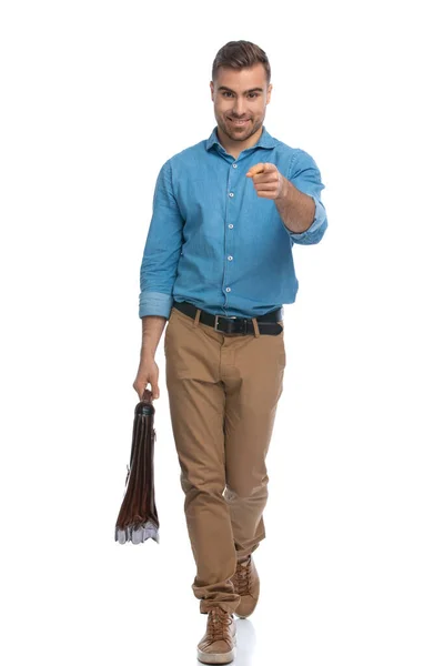 Homem Casual Bonito Apontando Para Câmera Andando Segurando Uma Pasta — Fotografia de Stock