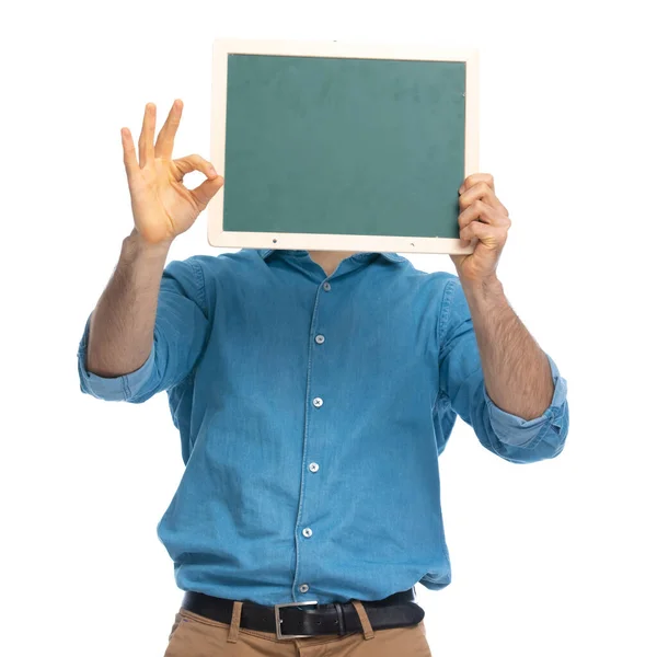 Casual Man Gömmer Sig Bakom Bräda Och Göra Tecken Mot — Stockfoto