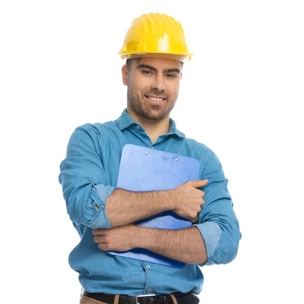 Giovane Uomo Casuale Tenendo Gli Appunti Stretti Petto Indossando Hardhat — Foto Stock