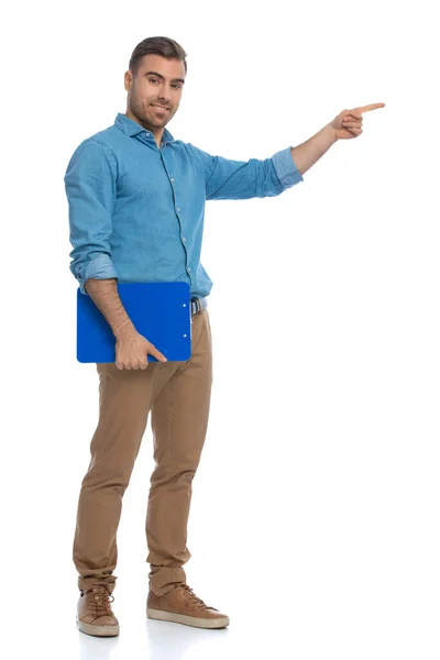 Νεαρός Casual Άνθρωπος Δείχνει Προς Μια Πλευρά Κρατώντας Ένα Μπλε — Φωτογραφία Αρχείου