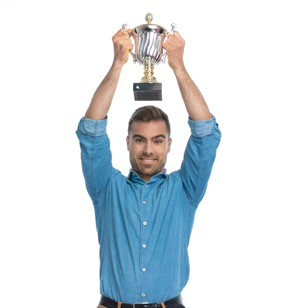 Homem Casual Atraente Segurando Sua Sobrecarga Troféu Sorrindo Contra Fundo — Fotografia de Stock