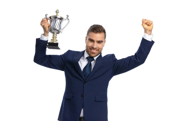 Portrait Enthusiastic Man Navy Blue Suit Holding Arms Silver Trophy — Stock Photo, Image