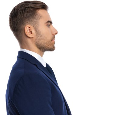 Lacivert takım elbiseli yakışıklı bir gencin portresi. Stüdyoda beyaz arka planda kuyrukta bekliyor.