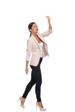 Pembe ceketli, el ele tutuşan, el kol hareketi yapan, stüdyoda beyaz arka planda yürüyen, tüm vücuduyla