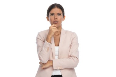 Pembe ceketli, kollarını kavuşturup beyaz arka planda sürpriz bir şekilde ağzını açan genç iş kadınının portresi.