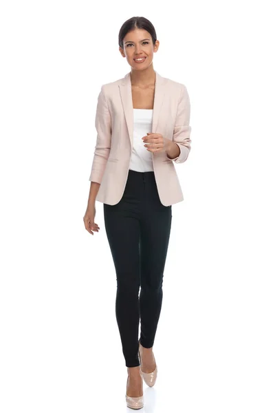 快乐的年轻女商人穿着粉红色的夹克 面带微笑 在工作室的白色背景上独立行走 浑身是劲 — 图库照片