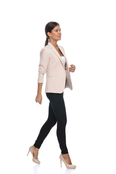 ピンクのジャケット姿のスマートなカジュアルな女性が自信を持って歩きスタジオの白い背景で笑顔で全身 — ストック写真