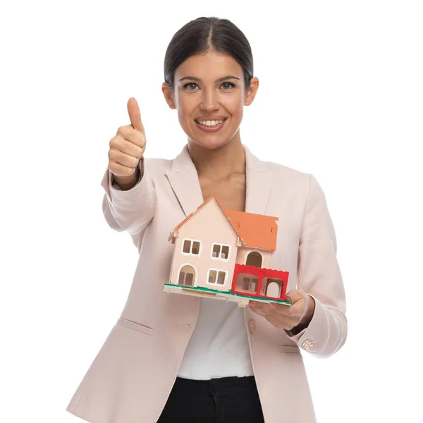 Young Businesswoman Pink Jacket Making Thumbs Gesture Presenting Building Model — Stock Photo, Image