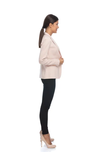 幸せなビジネスマン女性でピンクのジャケット待っていますライン 笑顔と調整ジャケット上の白い背景でスタジオ — ストック写真