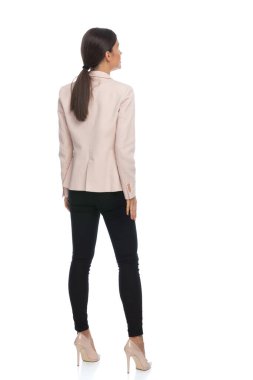 Stüdyoda beyaz arka planda duran ve poz veren seksi genç iş kadınının tüm vücudu.