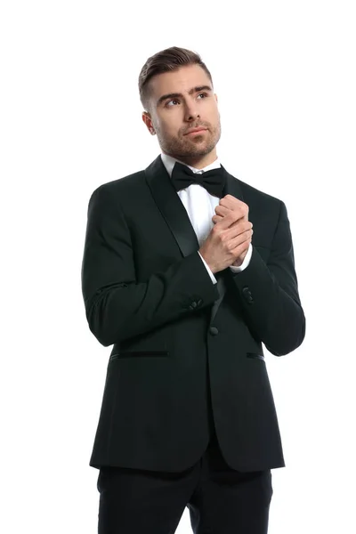 ブラックベルベット タキシードを着たエレガントな若いビジネスマンが手を携えて立ち上がり スタジオで白い背景に立ってポーズをとって — ストック写真