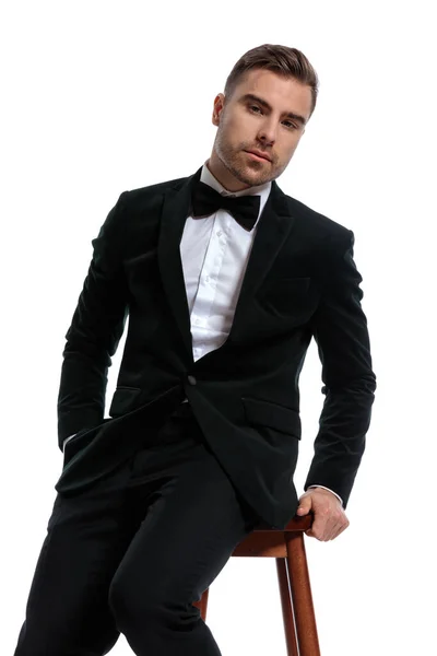 Young Businessman Black Tuxedo Bowtie Sitting Wooden Chair Posing White — Stock Photo, Image