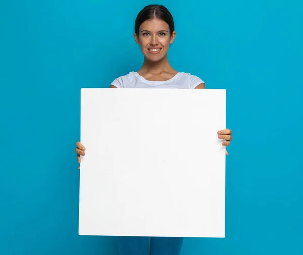 Glückliche Lässige Frau Präsentiert Vor Blauem Hintergrund Ihre Plakatwand Die — Stockfoto